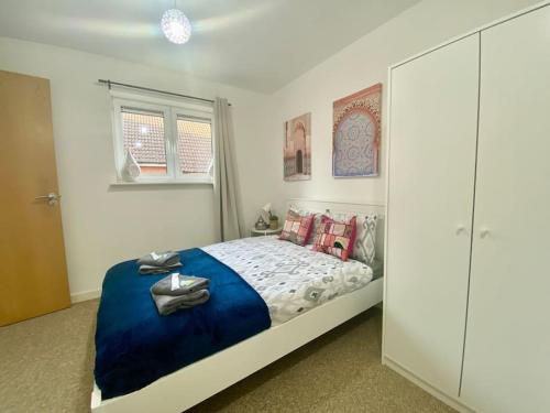 a bedroom with a large bed with a blue blanket at Moroccan Inspired Northampton Apartment in Northampton