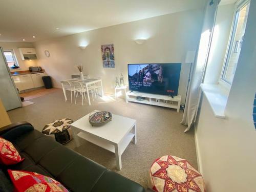 a living room with a couch and a tv at Moroccan Inspired Northampton Apartment in Northampton