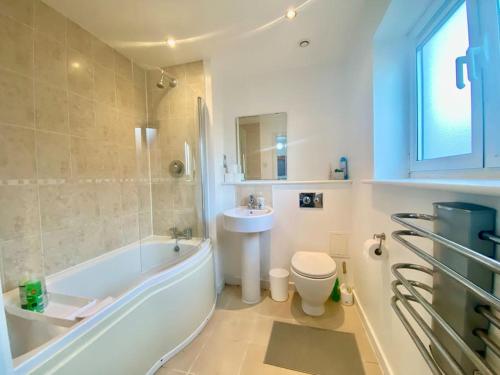 een badkamer met een bad, een toilet en een wastafel bij Moroccan Inspired Northampton Apartment in Northampton