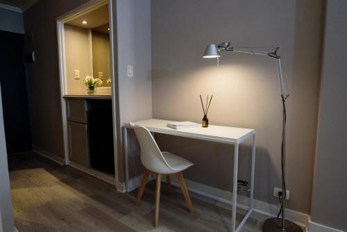 布宜諾斯艾利斯的住宿－SuMa Recoleta Hotel，一张桌子,椅子和一盏灯放在房间里