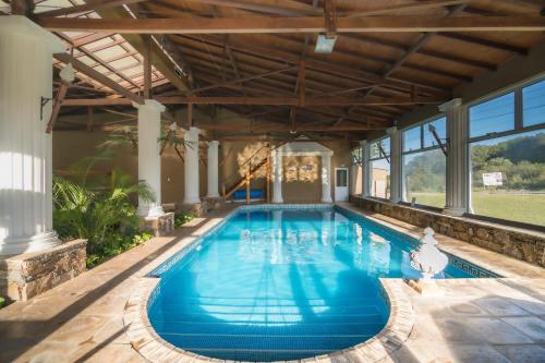 una piscina cubierta con un gran techo y ventanas en Cabañas y Spa Las Pircas en Tandil