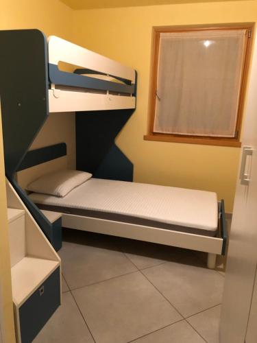 Ce lit superposé se trouve dans un dortoir doté d'une fenêtre. dans l'établissement casa Olivieri, à Carisolo