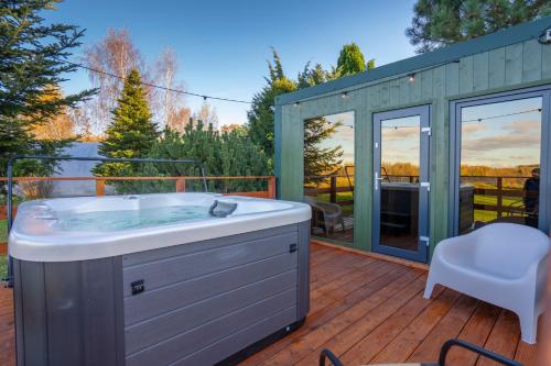 a hot tub on a deck with a gazebo at Izera Glamping Adults - Luksusowe jurty&spa (adults only) in Gajowka