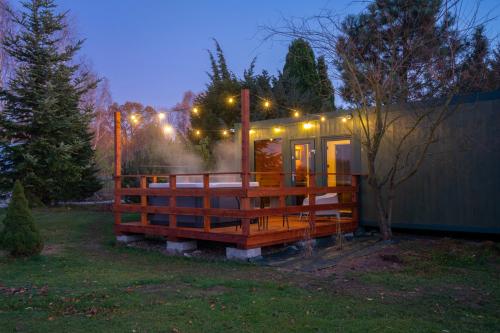 a small house with lights on it in a yard at Izera Glamping Adults - Luksusowe jurty&spa (adults only) in Gajowka