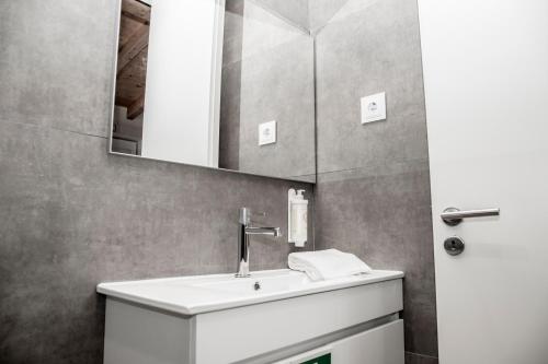a bathroom with a white sink and a mirror at Casa de Couros in Guimarães