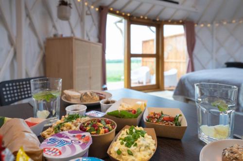 a table with bowls of food on top of it at Izera Glamping Adults - Luksusowe jurty&spa (adults only) in Gajowka