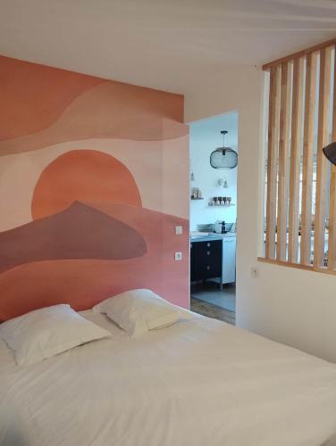 a bedroom with a large bed with a painting on the wall at * LE CHAMARELLE * Hyper Centre Auray * in Auray