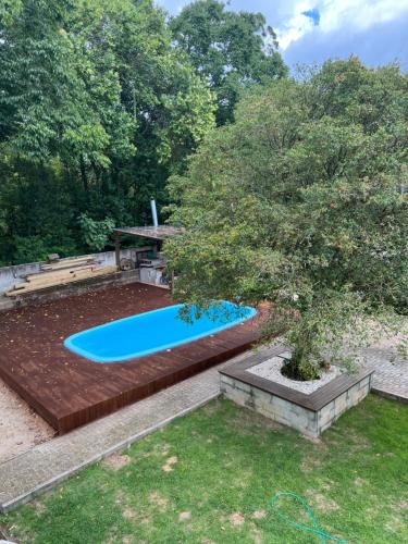 a swimming pool in a yard with a tree at Chalés no meu quintal in Louro Müller