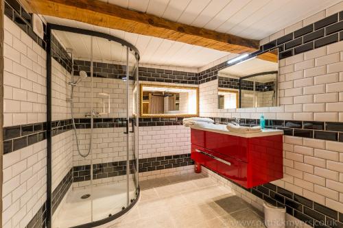 a bathroom with a red sink and a shower at Luxury Chalet with outdoor Hot Tub, Sauna, Gardens & Mountain Views! in Briançon
