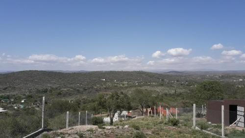 a view of a hill with trees and a city at Cabañas Teodoro in Tanti