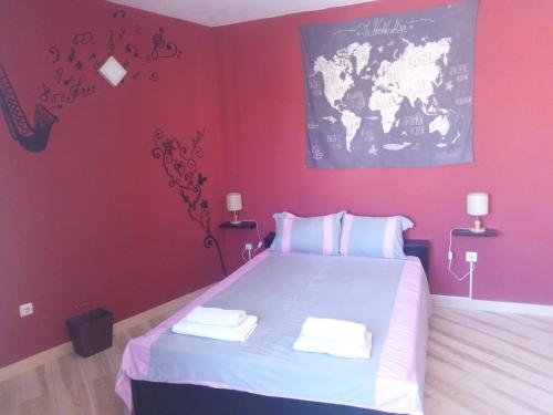 a bedroom with a large bed with red walls at Appart Chris Mindelo in Mindelo