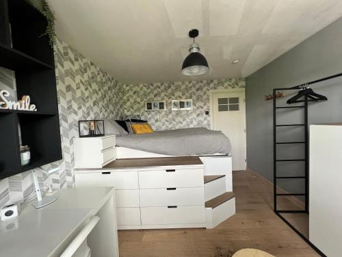 a bedroom with a bed with white drawers at Bed & Bokes aan de Maaskant in Lanaken