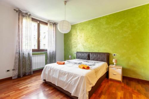 een slaapkamer met een bed en een groene muur bij Casa Azzurra - by Host4U in San Donato Milanese