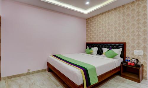 a bedroom with a large bed with green pillows at Treebo Three Street Inn in Bengaluru