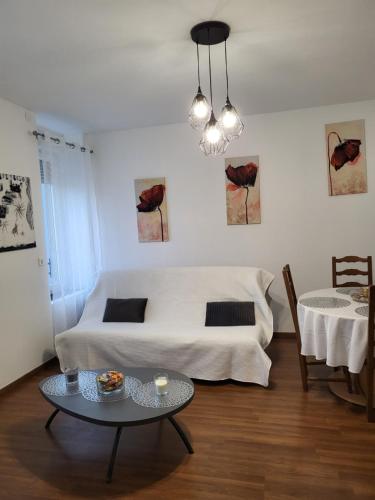 ein Wohnzimmer mit einem Bett und einem Tisch in der Unterkunft Le Saint Max in Saint-Max