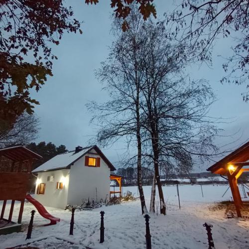 a house in the snow with lights on at Smocze Ranczo 2 in Ośno Lubuskie