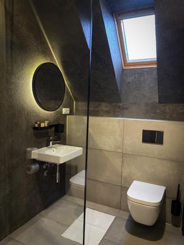 a bathroom with a sink and a toilet and a window at DOMA u nás Boutique hotel & spa in Poprad