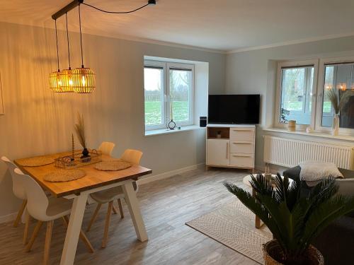 ein Wohnzimmer mit einem Esstisch und einem TV in der Unterkunft Ferienwohnung Watt'n Weitblick in Simonsberg