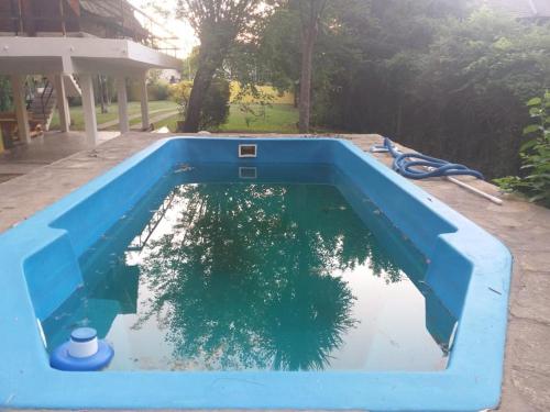 Una piscina azul con un árbol. en LA ALPINA en Dique Luján