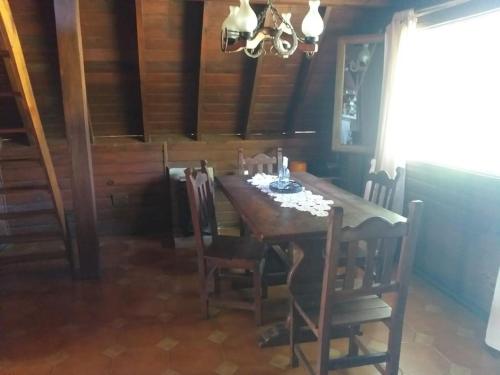 comedor con mesa de madera y sillas en LA ALPINA en Dique Luján