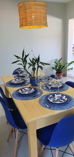 a wooden table with plates and wine glasses on it at Casa Romão I - Charme perto de Vinícola e Centro in Espirito Santo Do Pinhal