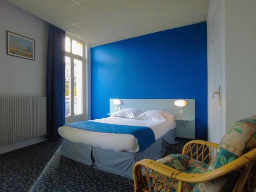 a blue room with a bed and a chair at Le CESAR HOTEL in Royat