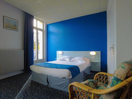 een blauwe kamer met een bed en een stoel bij Le CESAR HOTEL in Royat