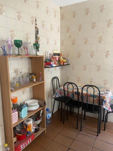 a kitchen with a table and chairs in a room at Casa da Si Hostel in Ubatuba