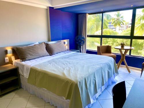 1 dormitorio con cama grande y ventana grande en IMPERIAL SUÍTES Flat - Cabo Branco by PenareiaTurBr, en João Pessoa