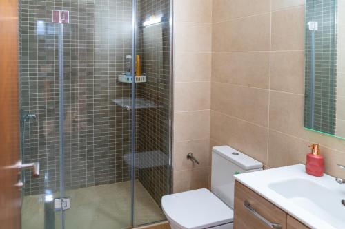 a bathroom with a shower with a toilet and a sink at PUERTO MARINA ASILAH in Asilah