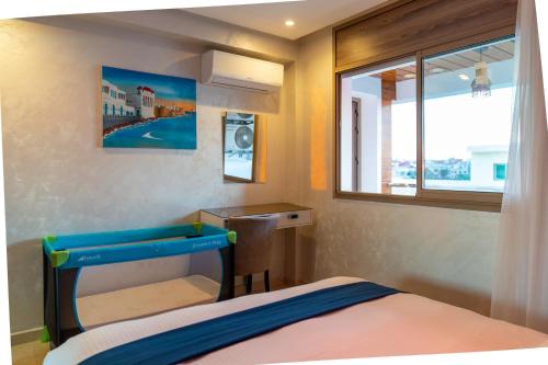 a small bedroom with a bed and a window at PUERTO MARINA ASILAH in Asilah