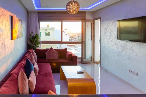 a living room with a couch and a tv at PUERTO MARINA ASILAH in Asilah
