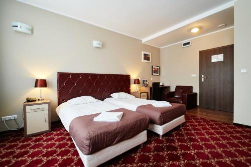a hotel room with two beds and a red carpet at Apartamenty-Europejska in Suwałki
