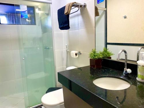 y baño con aseo, lavabo y ducha. en IMPERIAL SUÍTES Flat - Cabo Branco by PenareiaTurBr, en João Pessoa