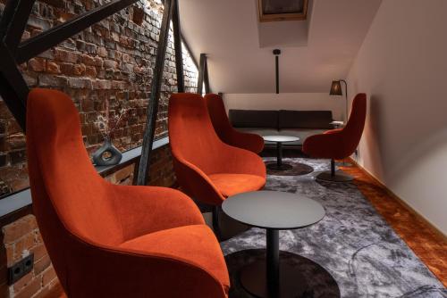a waiting room with orange chairs and a couch at Dunten Hotel in Tallinn