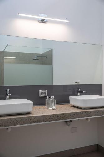 a bathroom with two sinks and a large mirror at Hilltop Bayview Luxury Apartments in Plettenberg Bay