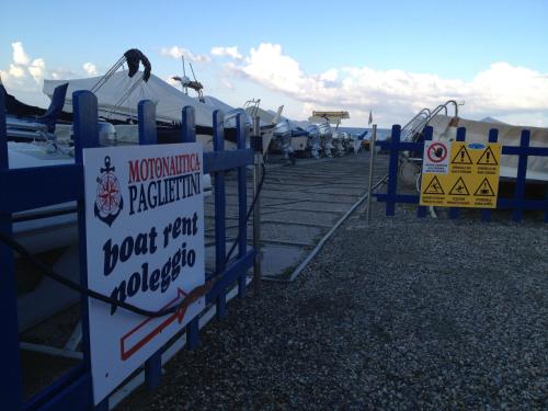 a bunch of signs on a fence with boats at La Casa Di Menny Maison de Campagne in Moneglia