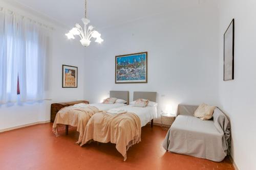 フォルリにあるRomagnaBNB Campostrinoのベッド3台とソファが備わる部屋