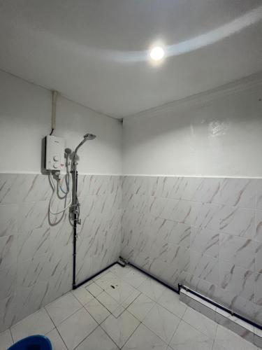 タワウにあるYushas Homestayの白い壁のバスルーム(シャワー付)