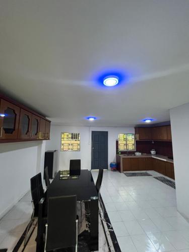 a room with a table and chairs and a kitchen at Yushas Homestay in Tawau