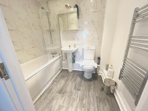 a bathroom with a sink and a toilet and a bath tub at Home Crowd Luxury Apartments - Grangefield House in Cantley