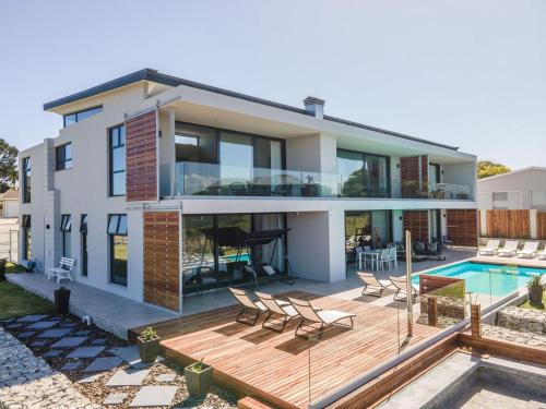 a house with a deck and a swimming pool at Hilltop Bayview Luxury Apartments in Plettenberg Bay