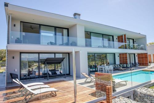 a house with a swimming pool and a villa at Hilltop Bayview Luxury Apartments in Plettenberg Bay