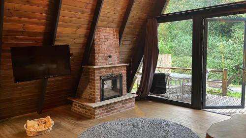 a living room with a fireplace and a flat screen tv at Özlifesapanca Bungalow in Sapanca