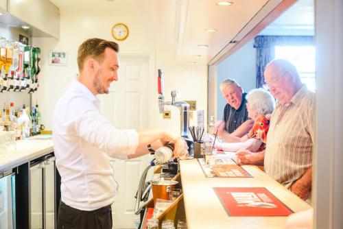 a man standing at a bar pouring a drink at Russell Hotel in Weymouth