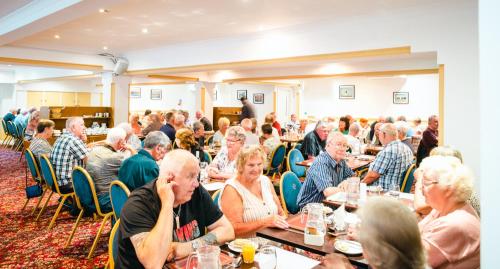 a large group of people sitting at tables in a room at Russell Hotel in Weymouth