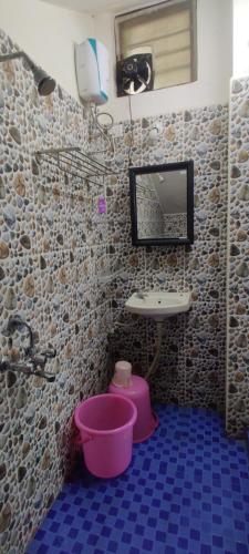 een badkamer met een wastafel en een roze emmer bij Mahabs homestay Villa in Mahabalipuram