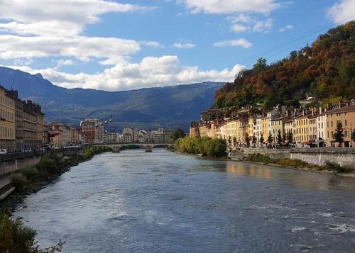 a river in a city with a bridge and buildings at Appartement confortable à Lans-en-Vercors 85 m² vue montagne in Lans-en-Vercors