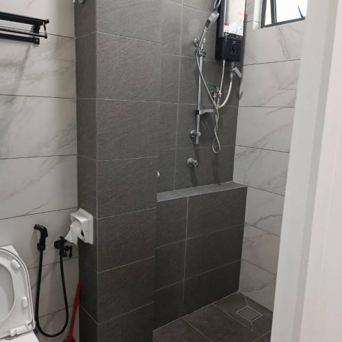 a bathroom with a shower with a stone wall at SBB Star Homestay in Sungai Petani