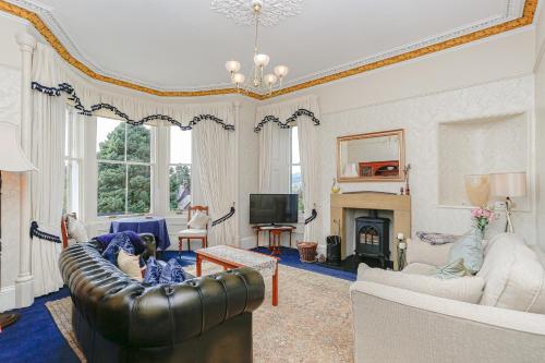 a living room with a couch and a fireplace at Arden House B&B and Self-Catering in Callander